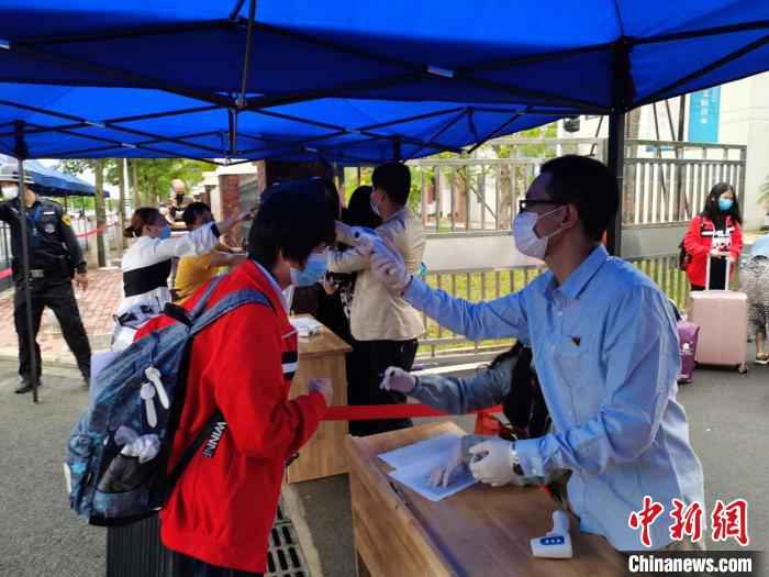 6日下午,北师大海口附属学校对返校学生测量体温。 张茜翼 摄  海南高三、初三开学 单人单桌上课错时就餐