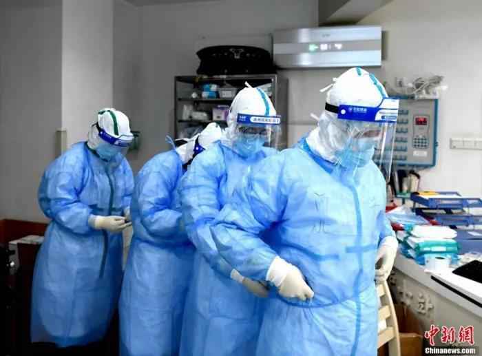 3月8日是国际妇女节,在武汉市红十字会医院里,来自四川、河北、上海等多支医疗队的女医护人员依旧奋战在抗“疫”一线。图为护士们在做进病区的防护工作。安源 摄  天使,节日快乐!